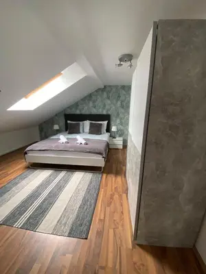 a bedroom with a bed on a wooden floor at Apartma Špela in Slivnica pri Mariboru