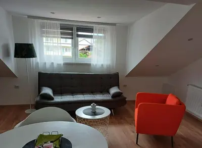 a living room with a couch and a red chair at Apartma Špela in Slivnica pri Mariboru