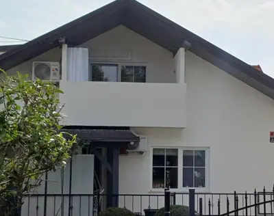 a white house with a fence in front of it at Apartma Špela in Slivnica pri Mariboru
