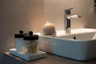 a bathroom sink with a candle and a soap dispenser at Kalan Boutique Stay in Žirovnica