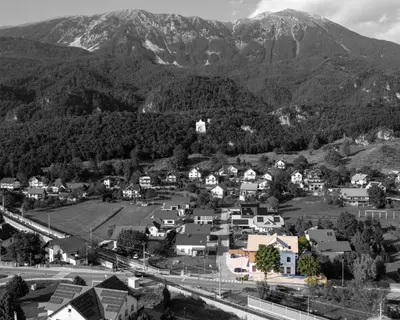 a black and white photo of a town with mountains at Kalan Boutique Stay in Žirovnica