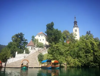 a group of boats on the water in front of a building at Kalan Boutique Stay in Žirovnica