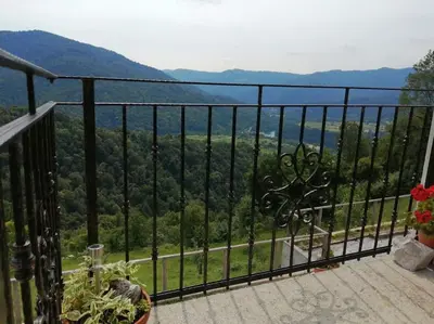 a balcony with a view of the mountains at Apartma na podeželju - Slovenia Nature in Kanal