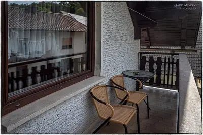 a patio with two chairs and a table and a window at Turistična kmetija Markun in Golnik