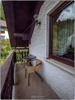 a patio with two chairs and a table and a window at Turistična kmetija Markun in Golnik