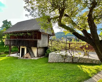 a building with a grassy yard next to a fence at House 44 in Bled