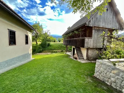 a barn with a grass yard next to a building at House 44 in Bled
