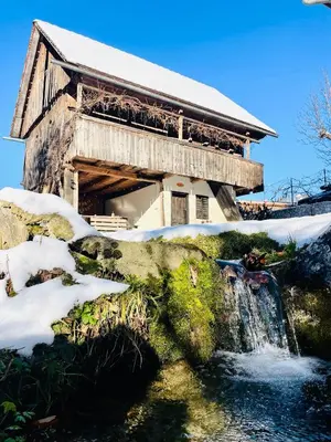 a wooden building with a waterfall in front of it at House 44 in Bled