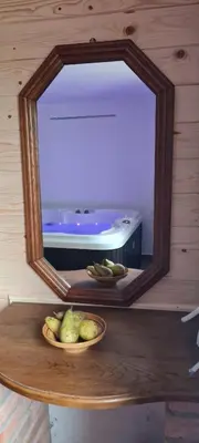 a mirror on a table with a bowl of fruit at Soba tete Tile - Hiša ob gozdu in Ptuj