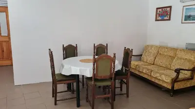 a dining room with a table and a couch at Soba tete Tile - Hiša ob gozdu in Ptuj
