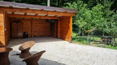 a wooden shed with two chairs in front of it at Soba tete Tile - Hiša ob gozdu in Ptuj