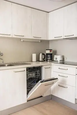 a kitchen with white cabinets and a dishwasher at Apartments Villa AnnaMaria in Bled