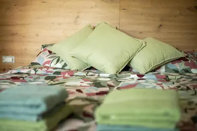 a bed with green pillows and sheets andimov at Zoya Bled Apartments in Bled