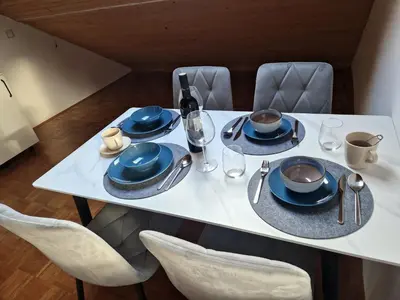 a white table with blue plates and napkins on it at Zoya Bled Apartments in Bled