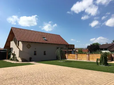 a white house with a fence in a yard at Apartments Galunder in Veržej
