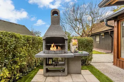 a stone oven with a fire in a yard at Superior Holiday Home Fortuna in Čatež ob Savi