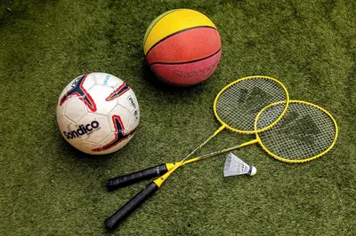 two tennis balls and tennis rackets on the grass at Superior Holiday Home Fortuna in Čatež ob Savi