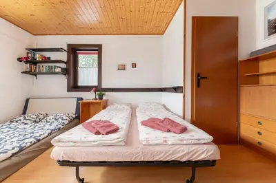 a bedroom with two beds and a wooden ceiling at First House - Lovely Holiday Home near Cerknica in Nova Vas