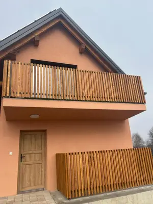 a house with a wooden balcony and a door at Ana Apartment in Gradišča