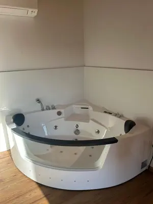 a white bath tub in a corner of a room at Ana Apartment in Gradišča