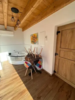 a room with a wooden door and a table and chairs at Ana Apartment in Gradišča