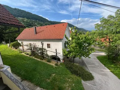 a small white house with a red roof at Vineyard cottage Kovačnica in Semič