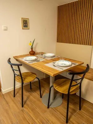 a wooden table with two chairs and a table with plates at Cottage in Novo Mesto 50797 in Novo Mesto