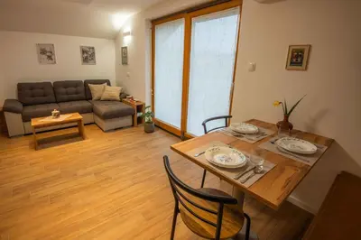 a living room with a table and a couch at Cottage in Novo Mesto 50797 in Novo Mesto