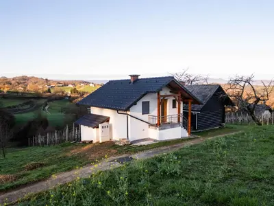 a small white house with a black roof at Cottage in Novo Mesto 50797 in Novo Mesto