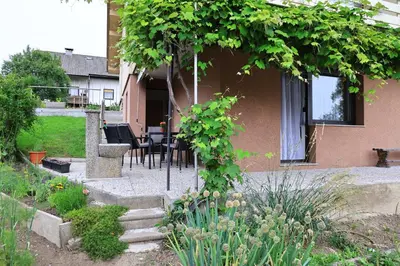a house with a table and chairs in a garden at Apartma Pers in Zgornje Gorje