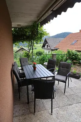 a wooden table and chairs on a patio at Apartma Pers in Zgornje Gorje