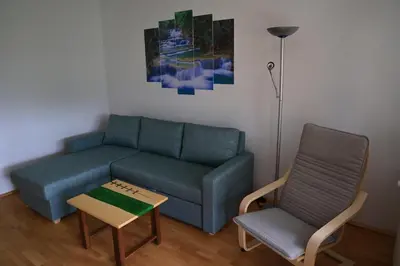 a living room with a couch and a chair at Apartma Pers in Zgornje Gorje