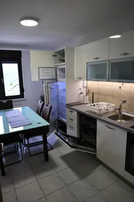 a kitchen with a sink and a table in it at Apartma Pers in Zgornje Gorje