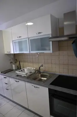 a kitchen with white cabinets and a sink at Apartma Pers in Zgornje Gorje