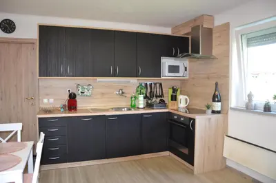 a kitchen with black cabinets and a sink at Aparthouse SUPREME with Terme Catez Swimming Pools Tickets in Čatež ob Savi