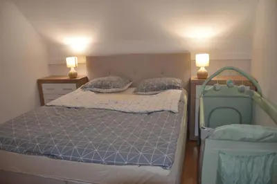 a small bedroom with a bed and two lamps at Aparthouse SUPREME with Terme Catez Swimming Pools Tickets in Čatež ob Savi