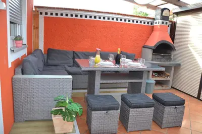 a patio with a table and a couch and a fireplace at Aparthouse SUPREME with Terme Catez Swimming Pools Tickets in Čatež ob Savi