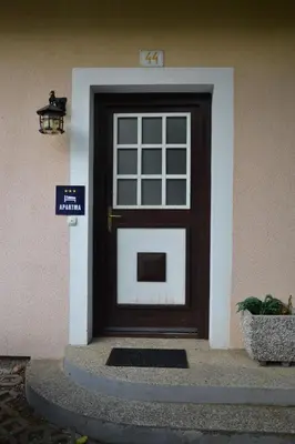 a door to a house with a sign in front at Aparthouse SUPREME with Terme Catez Swimming Pools Tickets in Čatež ob Savi
