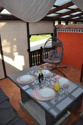a table with plates and wine glasses on a patio at Aparthouse SUPREME with Terme Catez Swimming Pools Tickets in Čatež ob Savi