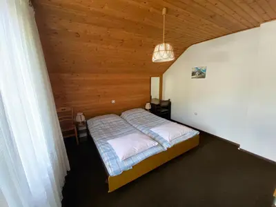a bedroom with a bed in a wooden room at Počitniško stanovanje ZALAR in Mojstrana