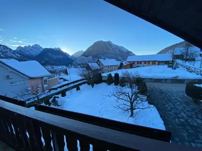 a view from a balcony of a town with snow at Počitniško stanovanje ZALAR in Mojstrana