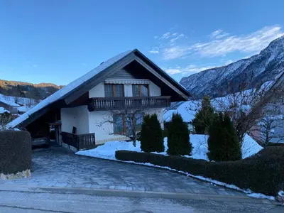 a house in the mountains with snow on the ground at Počitniško stanovanje ZALAR in Mojstrana