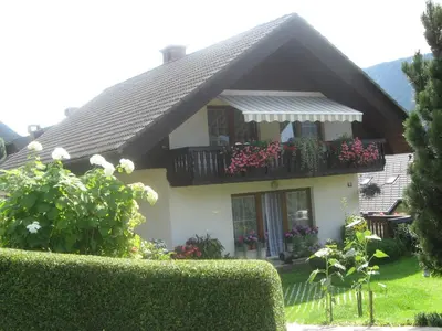 a house with a balcony with flowers on it at Počitniško stanovanje ZALAR in Mojstrana