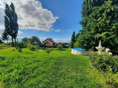 a field of grass with a house in the background at Apartma Grlica in Selnica ob Muri