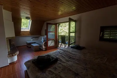 a bedroom with a large bed and a living room at Domačija Marinč in Kostel