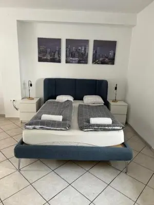 a bedroom with a blue bed with two pillows at Cozy flat near Tivoli park with free parking in Ljubljana