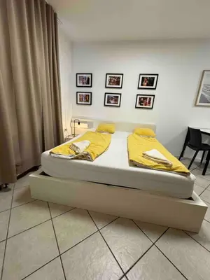a bedroom with a bed with yellow sheets on it at Cozy flat near Tivoli park with free parking in Ljubljana