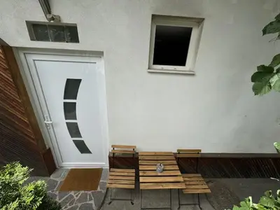 a wooden bench sitting in front of a building at Cozy flat near Tivoli park with free parking in Ljubljana