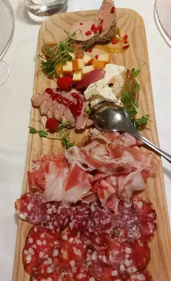 a cutting board with meat and other foods on it at Resort pri Hrastu in Kamnik
