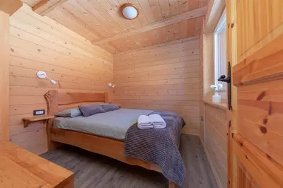 a bedroom with a bed in a wooden cabin at Resort pri Hrastu in Kamnik
